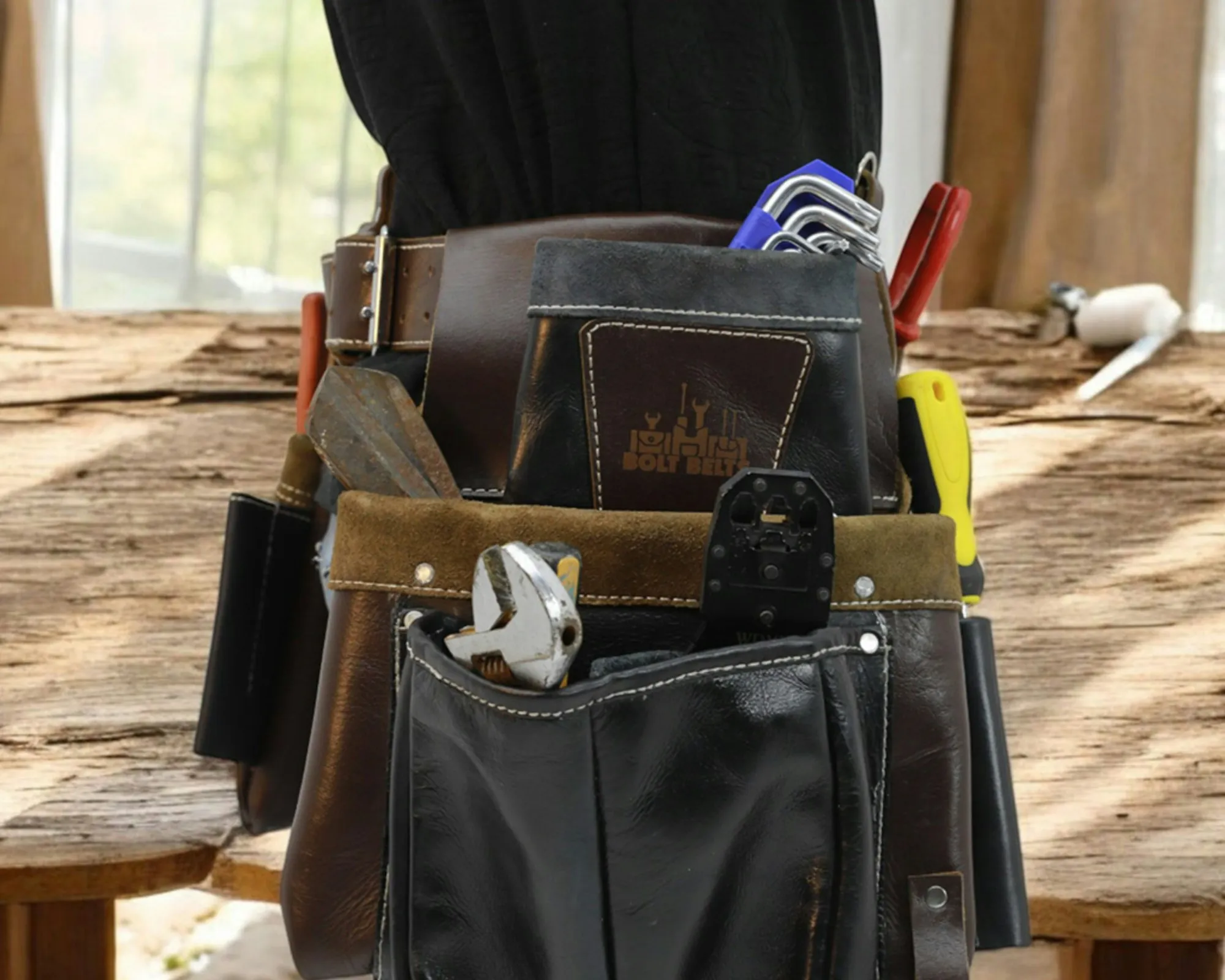 Electrical tool belt and pliers resting on a timber workbench