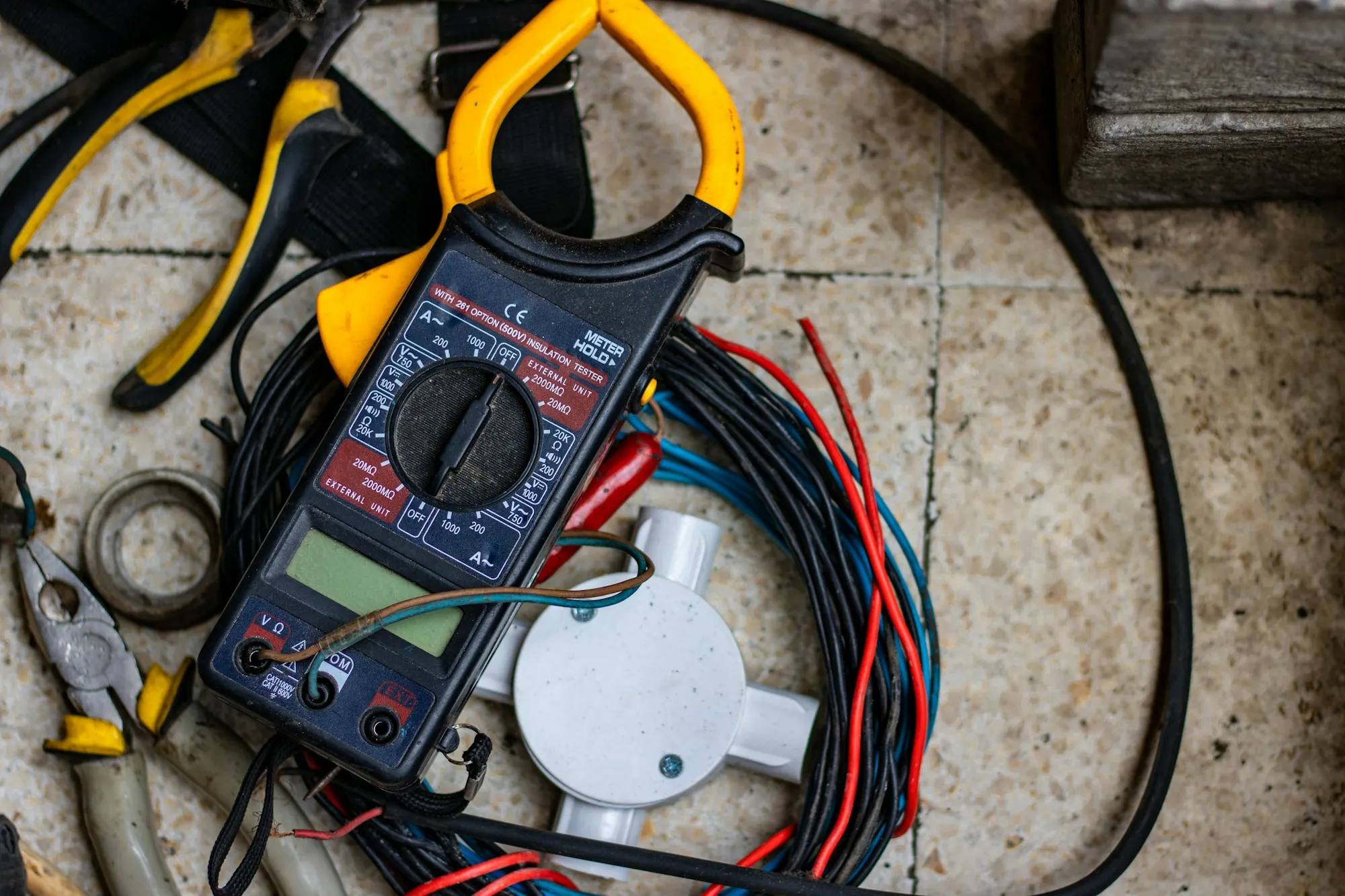 Multimeter and test probes laid across coiled wiring