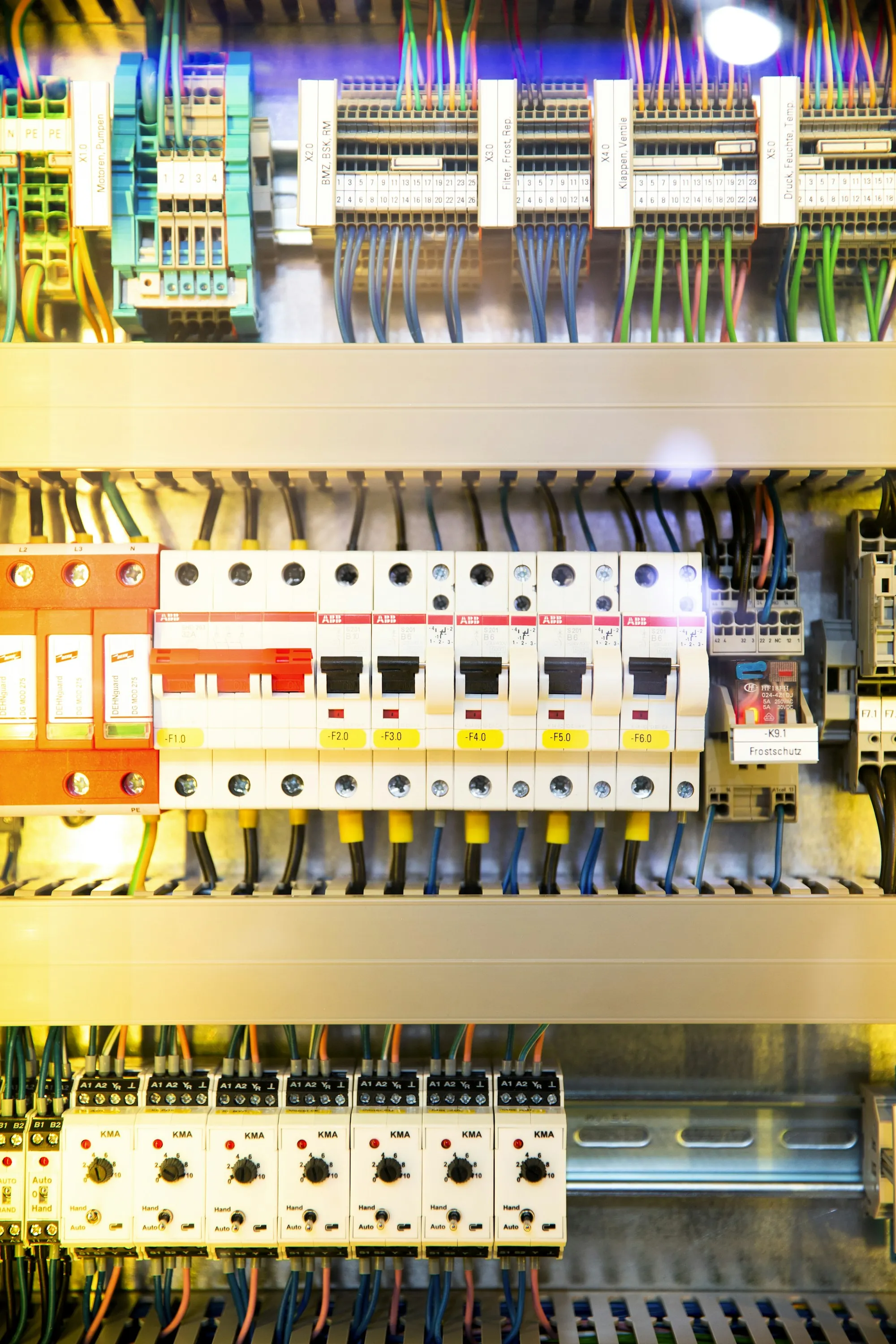 Gloved hand testing breaker terminals with a voltage probe