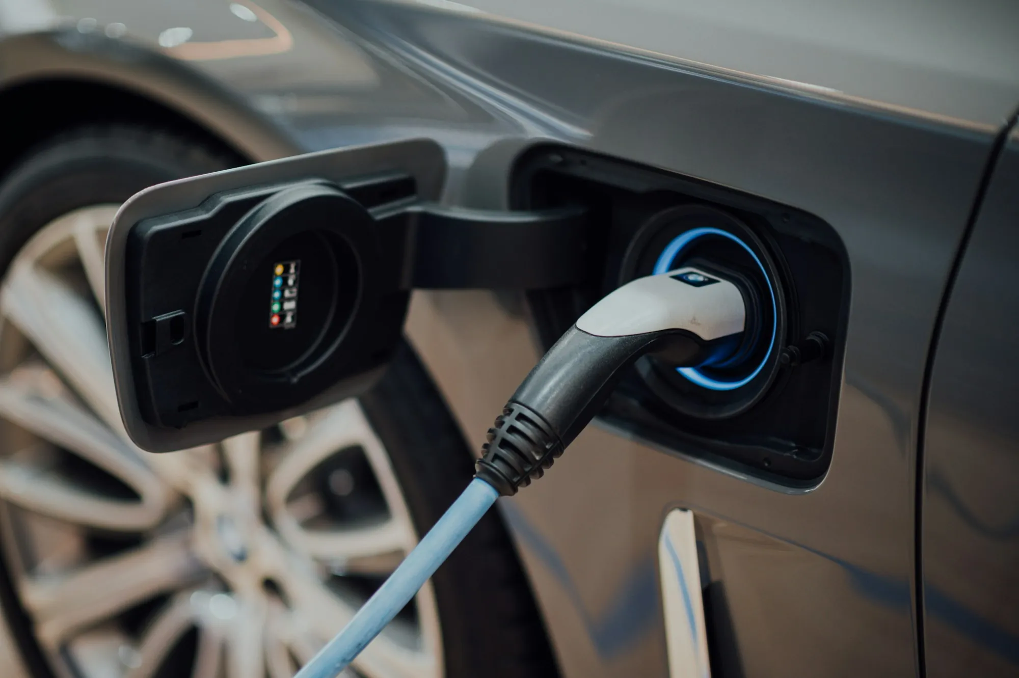 Electric vehicle plugged into a wall-mounted charger in a garage