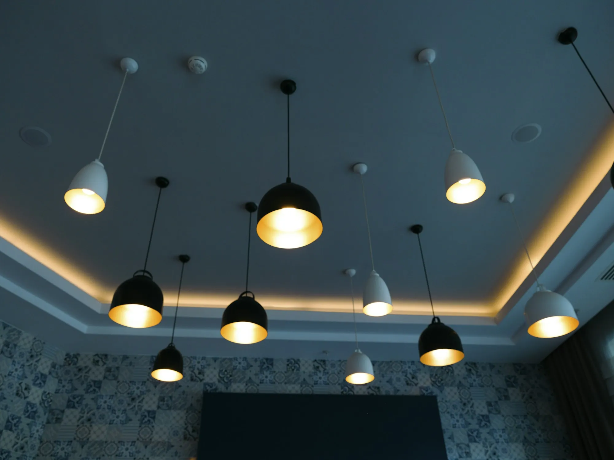 Black pendant lights hanging from a dark ceiling